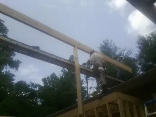 Carpenter setting a ridge beam over a new addition frame — Ice Dam Removal by Roofing Brothers in Fulton